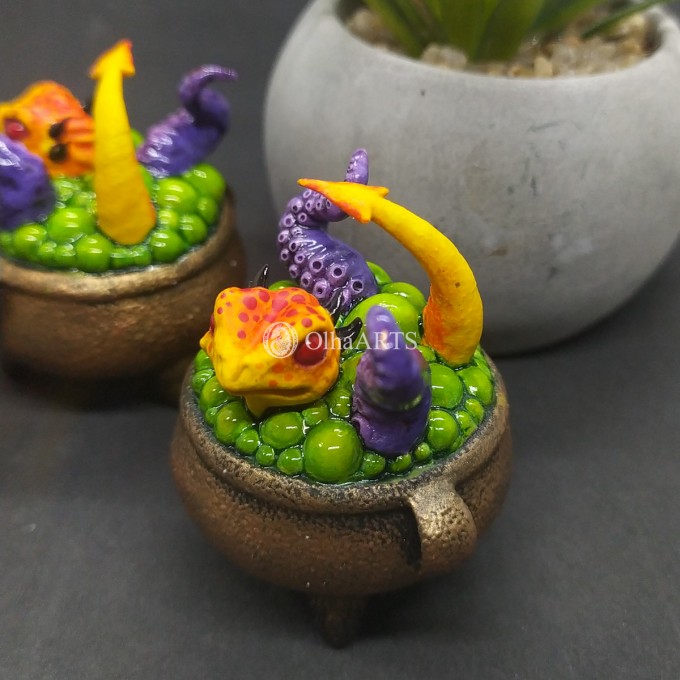 Mini figurine with a little dragon in a witch's cauldron