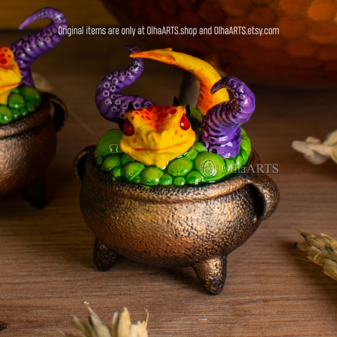 Mini figurine with a little dragon in a witch's cauldron